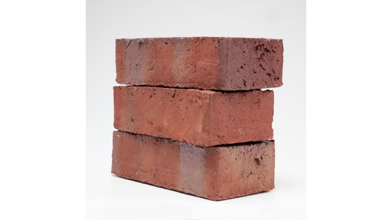 Drei übereinander gestapelte, rote Fassadenziegel in Backsteinoptik mit fein geriefter, gebrochener glatten Oberfläche. 